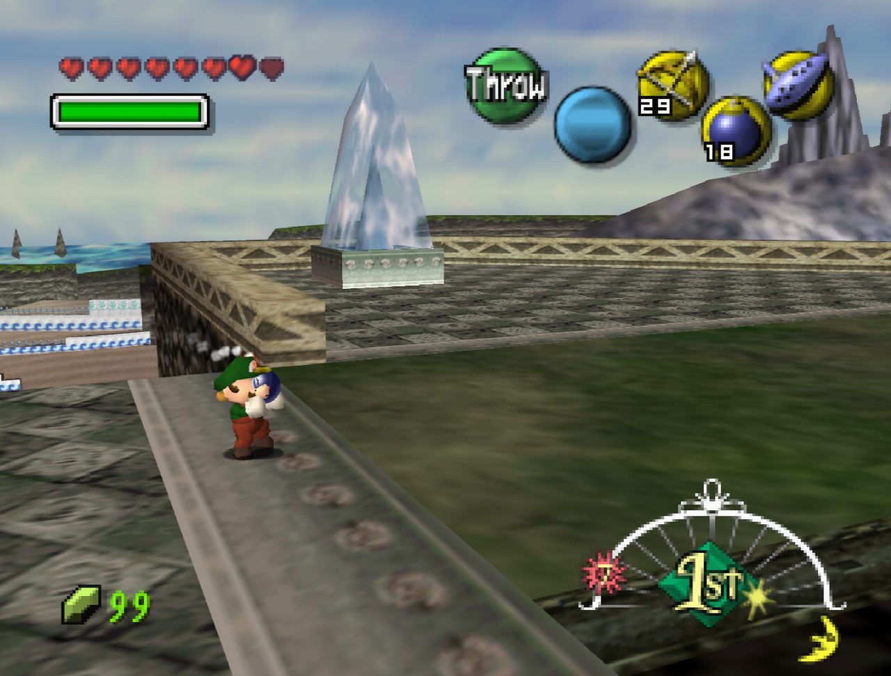 In-game screenshot: Mario carries a bomb above his head along a stone walkway in a town, with a crystal spire behind him.
